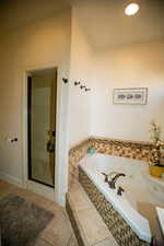 Bathroom featuring tile patterned floors and tiled bath