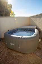 View of swimming pool with a hot tub