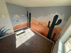 Workout area featuring carpet flooring and a textured ceiling