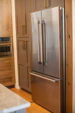 Kitchen with light wood-type flooring and appliances with stainless steel finishes