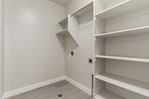 Laundry room featuring hookup for an electric dryer, washer hookup, and light wood-type flooring