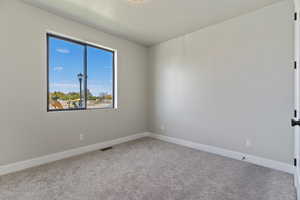 Unfurnished room with light carpet and a textured ceiling