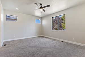 Unfurnished room featuring carpet flooring, ceiling fan, and a textured ceiling