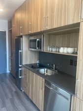 Kitchen featuring appliances with stainless steel finishes, dark hardwood / wood-style floors, and sink