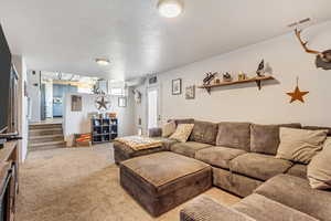 Carpeted living room with a textured ceiling