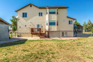 Back of house with a yard, a deck, and a patio area