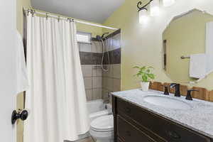 Full bathroom with vanity, toilet, and shower / tub combo with curtain