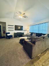 Carpeted living room with vaulted ceiling and ceiling fan