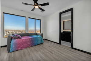 Bedroom featuring ceiling fan, light wood-type flooring, and connected bathroom