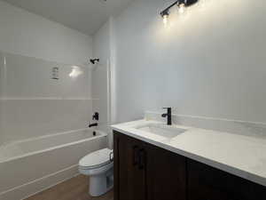 Full bathroom with bathtub / shower combination, wood-type flooring, vanity, and toilet