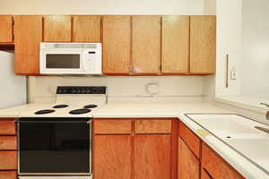 Kitchen featuring white appliances and sink