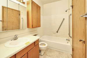 Full bathroom with tiled shower / bath, vanity, and toilet