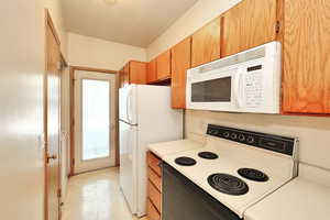 Kitchen with a textured ceiling and white appliances