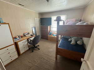 Carpeted bedroom featuring crown molding