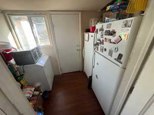 Clothes washing area with independent washer and dryer and dark wood-type flooring