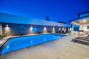 View of pool with an outdoor fire pit and a patio