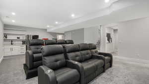 Home theater featuring light colored carpet and sink