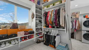 Walk in closet featuring stacked washing maching and dryer