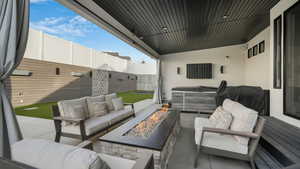 View of patio with an outdoor living space with a fire pit