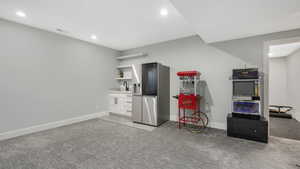 Kitchen featuring white cabinets, light carpet, stainless steel fridge with ice dispenser, and sink