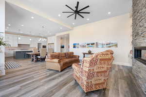 Living room with a stone fireplace and light hardwood / wood-style floors