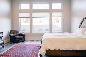 Bedroom with multiple windows and light hardwood / wood-style flooring