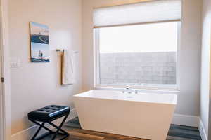 Bathroom with a washtub and hardwood / wood-style flooring