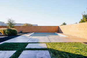 View of swimming pool with a patio area and a lawn