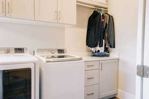 Washroom with cabinets and independent washer and dryer