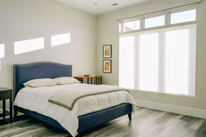 Bedroom featuring multiple windows and hardwood / wood-style floors