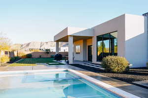 View of swimming pool featuring a mountain view, a yard, a patio, and an in ground hot tub