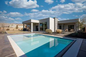 Rear view of property with a patio and a swimming pool with hot tub