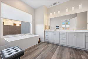 Bathroom featuring hardwood / wood-style flooring, a bathing tub, ceiling fan, and vanity