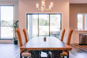 Dining area featuring an inviting chandelier, a healthy amount of sunlight, and hardwood / wood-style flooring