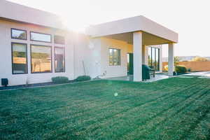 Rear view of property featuring a patio and a lawn