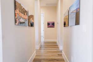 Hallway with hardwood / wood-style floors