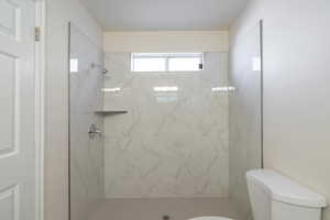 Bathroom with toilet and tiled shower