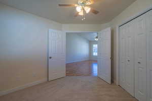 Interior space with light carpet and ceiling fan