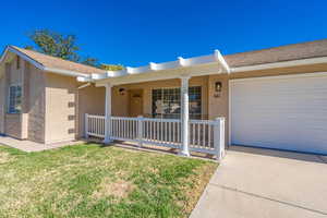 Single story home with covered porch, a garage, and a front lawn