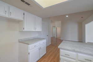 Kitchen featuring white cabinets and light hardwood / wood-style floors