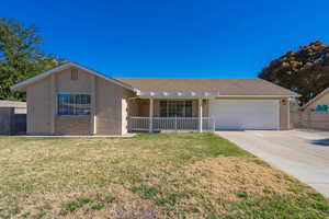 Ranch-style home with covered porch, a garage, and a front yard