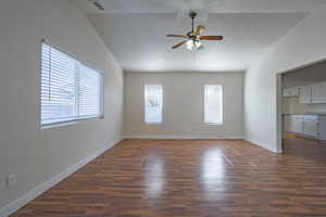 Unfurnished room featuring vaulted ceiling, ceiling fan, a textured ceiling, and dark hardwood / wood-style floors