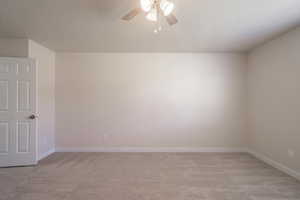 Spare room with light carpet, a textured ceiling, and ceiling fan