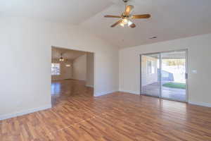 Unfurnished room with wood-type flooring, ceiling fan, and lofted ceiling