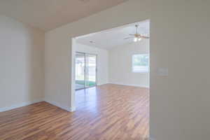 Spare room with ceiling fan, plenty of natural light, hardwood / wood-style floors, and vaulted ceiling