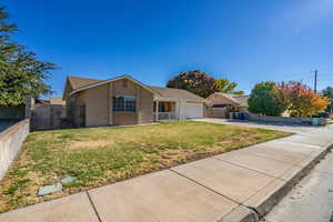 Single story home featuring a garage and a front yard