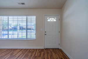 Entryway with a textured ceiling and dark hardwood / wood-style floors