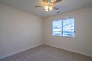 Carpeted spare room with ceiling fan