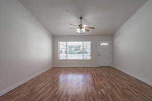 Interior space with ceiling fan, dark hardwood / wood-style flooring, and a textured ceiling