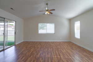 Unfurnished room featuring dark hardwood / wood-style floors, ceiling fan, and vaulted ceiling